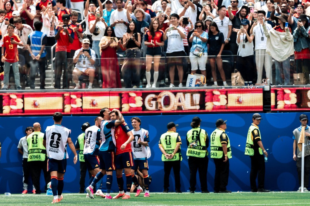 Spain players celebrate a goal as the stadium board flashes GOAL during the 2026 FIFA World Cup quarterfinal against Belgium