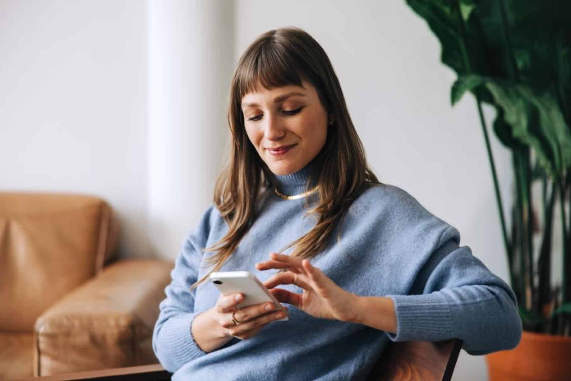 upscaled Businesswoman using a mobile phone in an office lobby