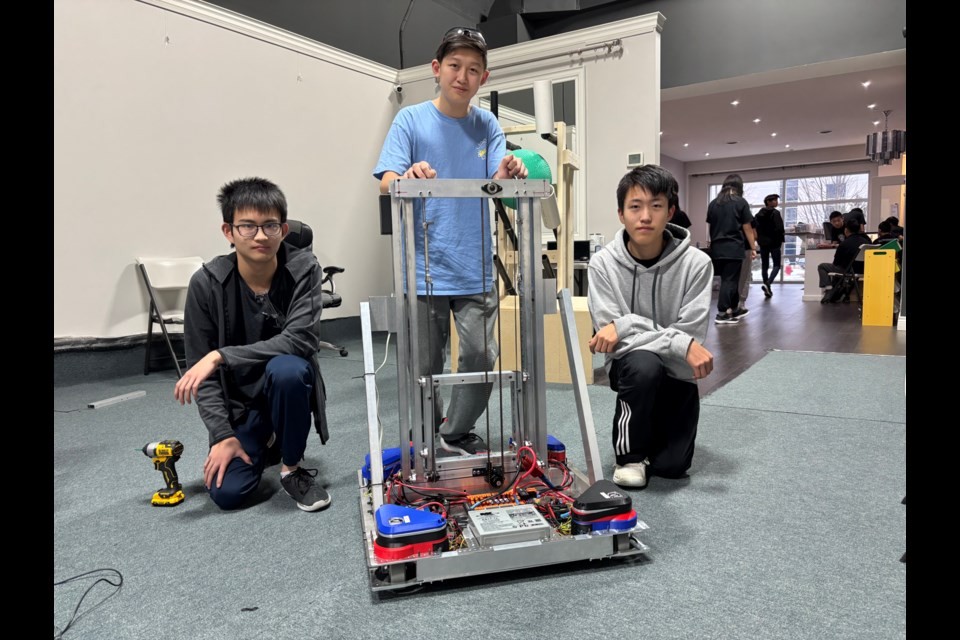 FRC 10015 Bubbles Team Captain Ryan Zhang showcases their Octomaster prototype along with Oliver and Felix