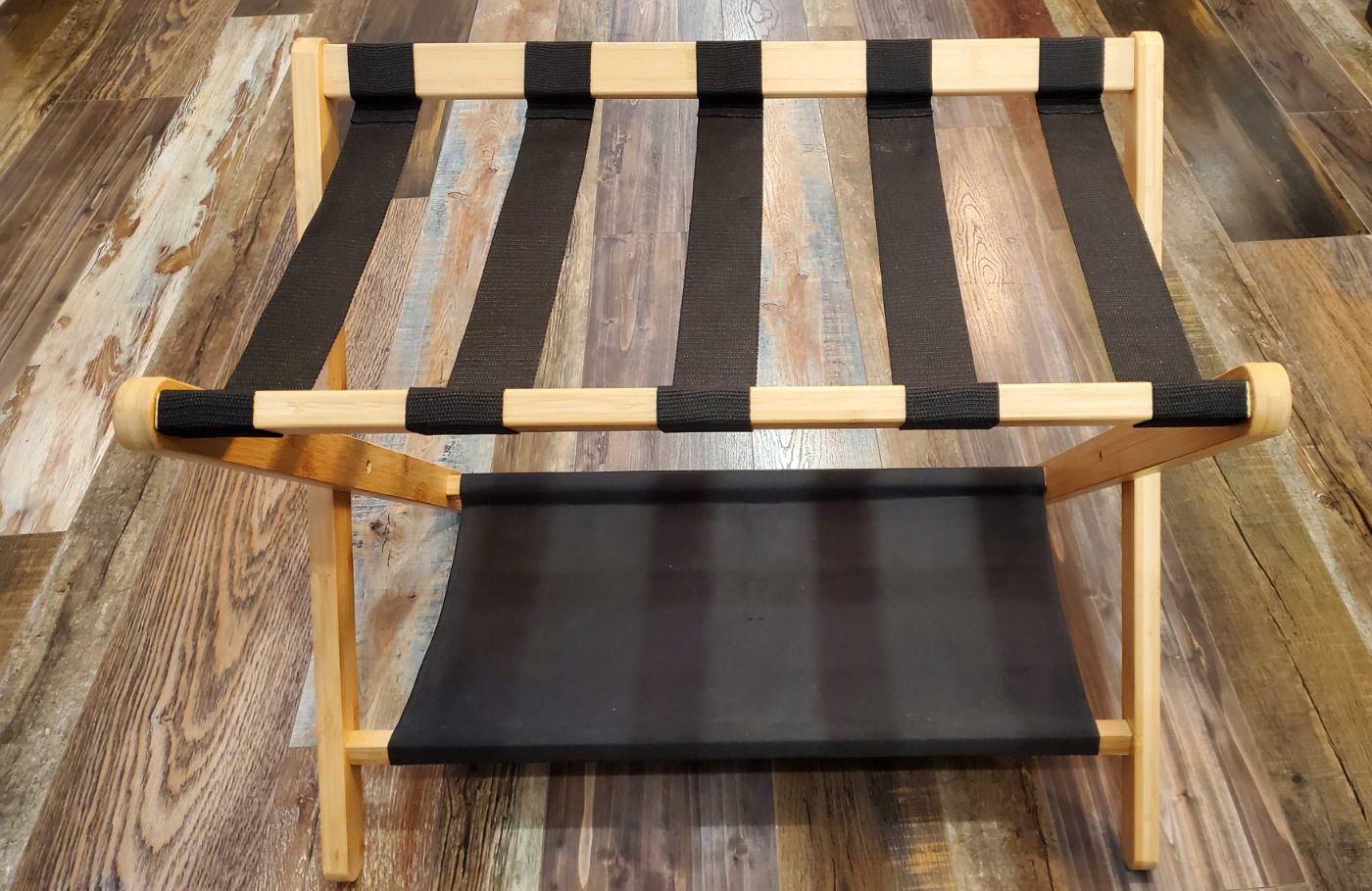 Repose-bagages en bois clair avec lanières noires, prêt à l’emploi, sur plancher moderne à Montréal Plateau Mont-Royal