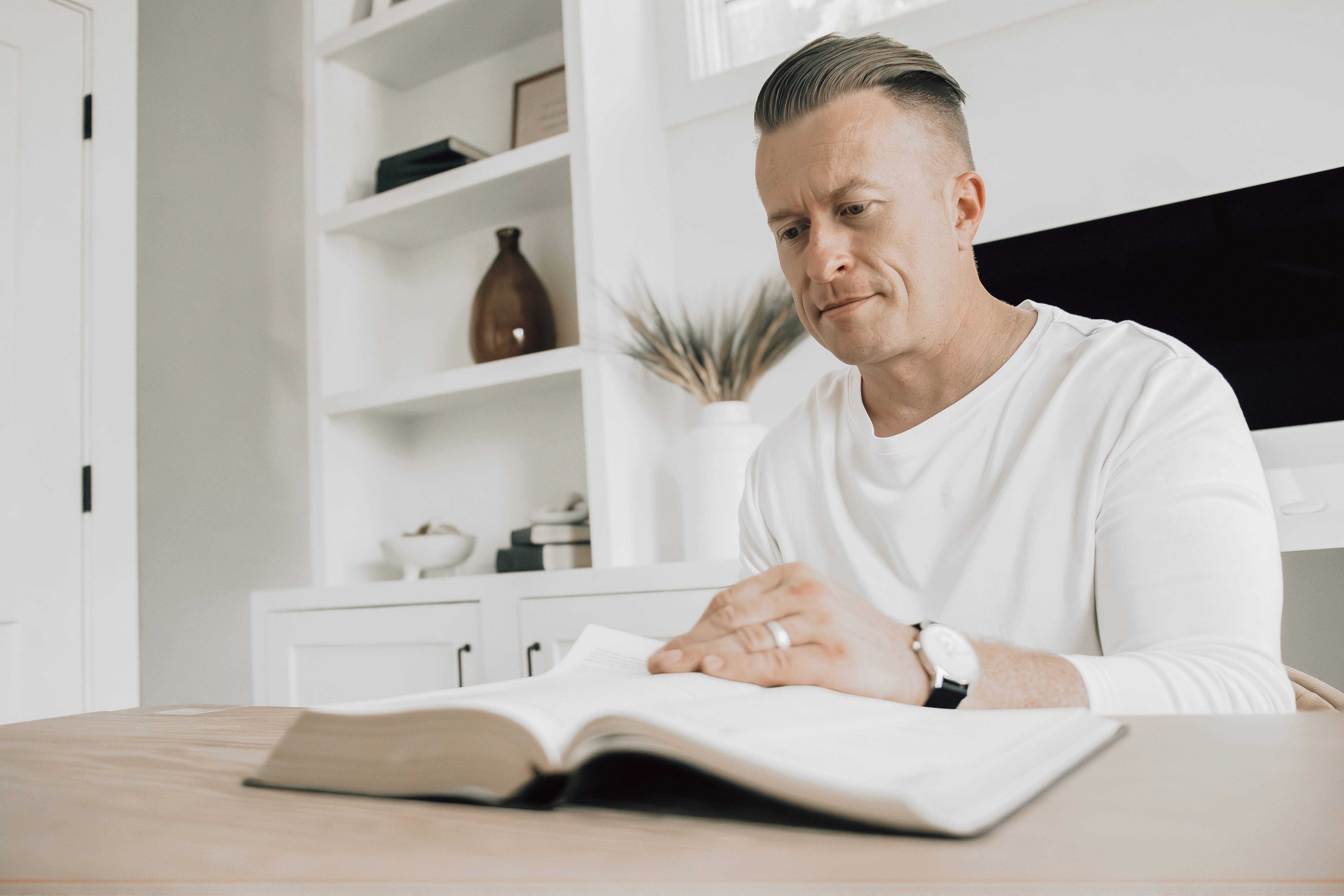 A white ramekin filled with chocolate mousse and topped with strawberries on a table. 