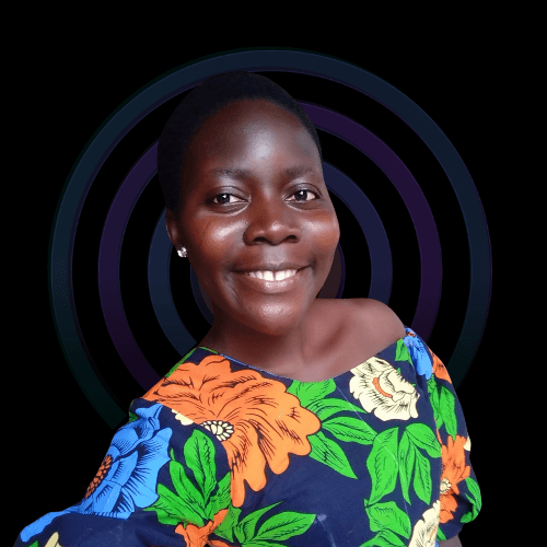 Porträt einer jungen Frau mit kurzem Haar, die lächelnd in die Kamera blickt. Sie trägt ein bunt gemustertes Kleid und steht vor einem schwarzen Hintergrund mit konzentrischen Kreisformen