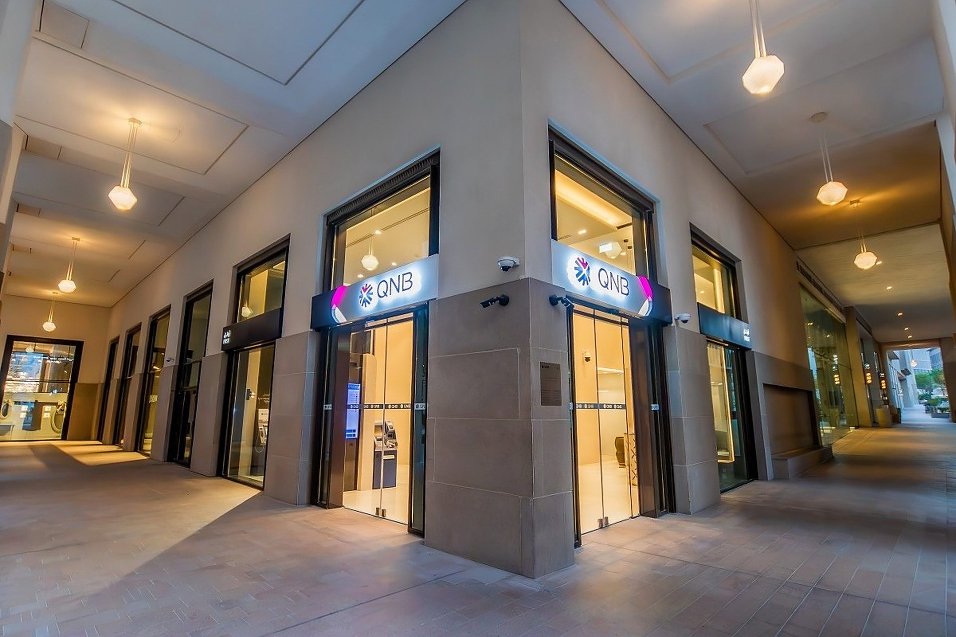 Une agence QNB à Msheireb Downtown, à Doha, avec son enseigne éclairée sur la rue