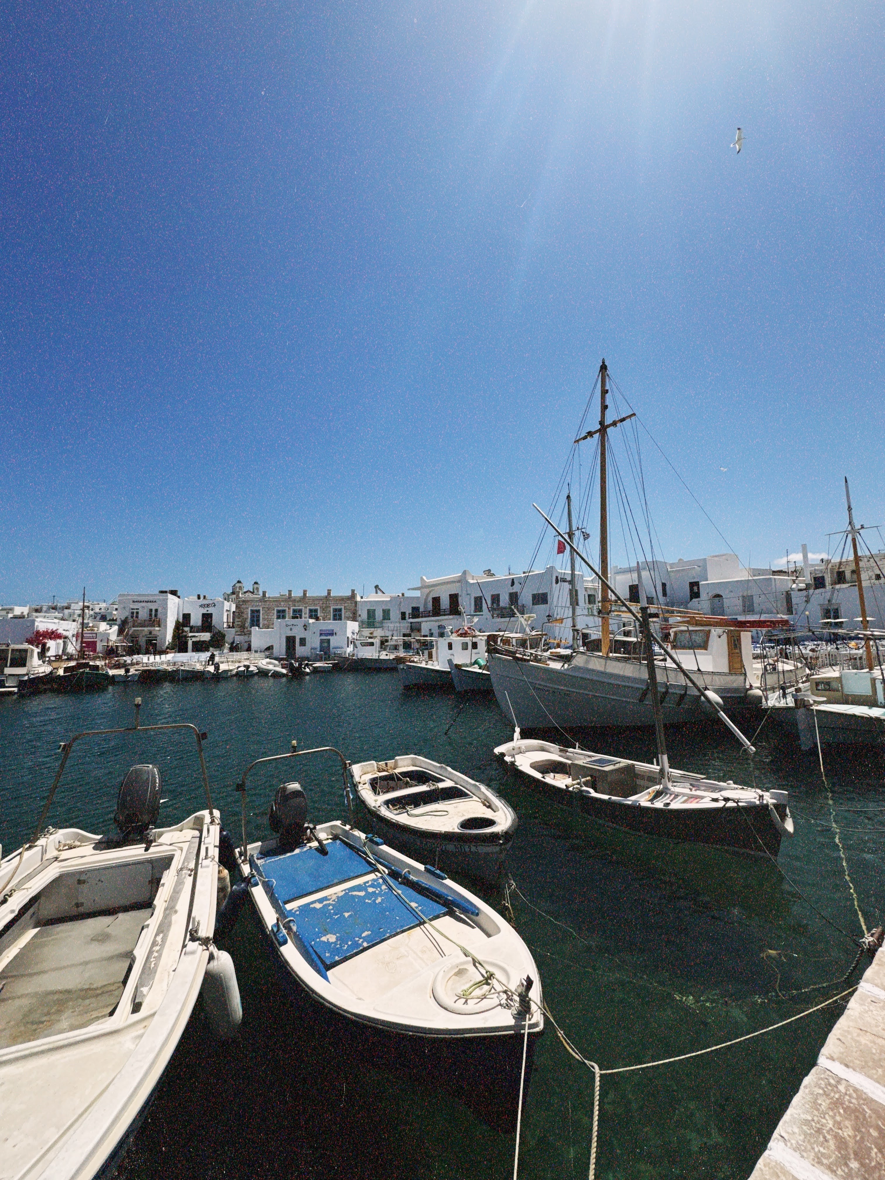 A port with boats under a bright sun in Greece