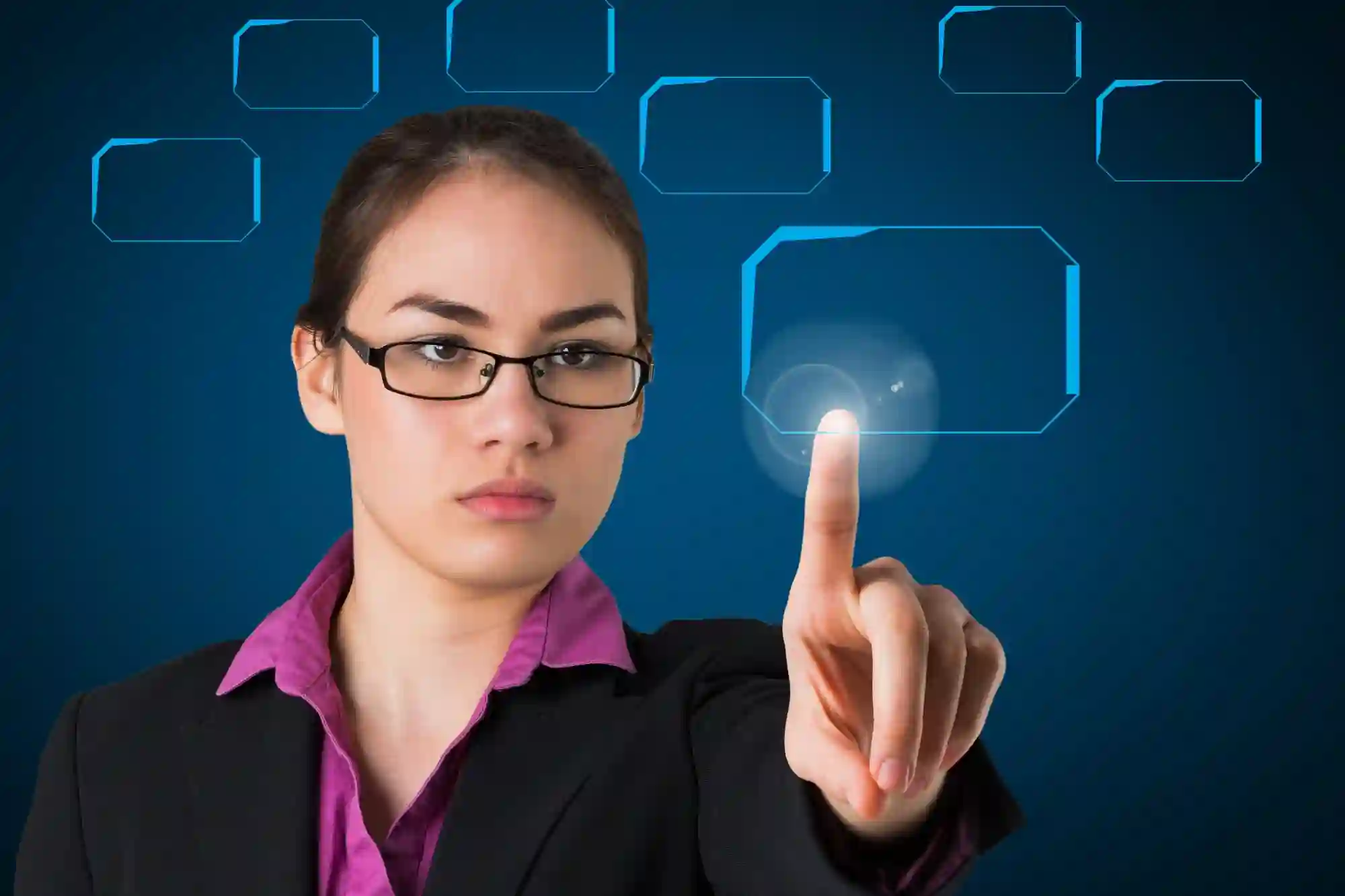 Focused professional woman in a suit interacting with a futuristic digital interface and glowing touchscreens on a blue background.