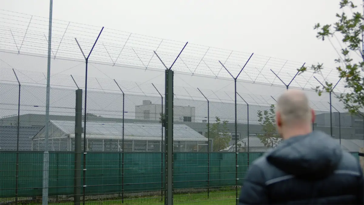 Still frame from Committed to Freedom showing a client looking at the forensic hospital from the outside.