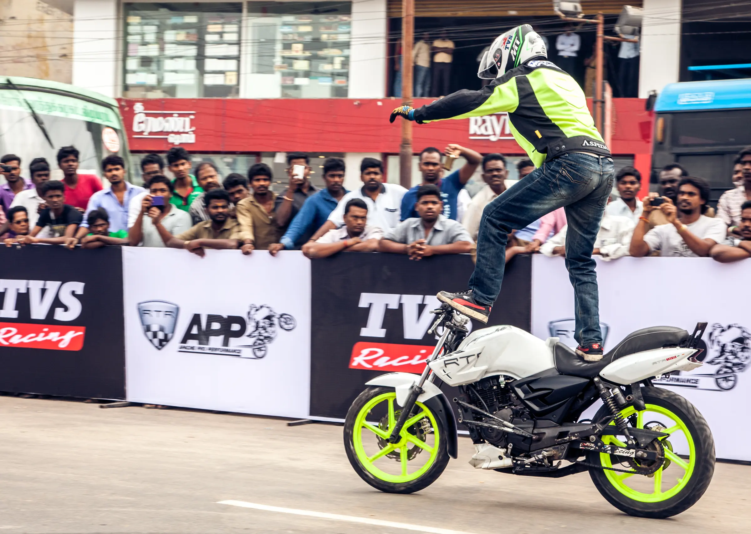 The motorcycle has visible TVS Appache features, showcasing extreme sport elements capture by Tapecassette media