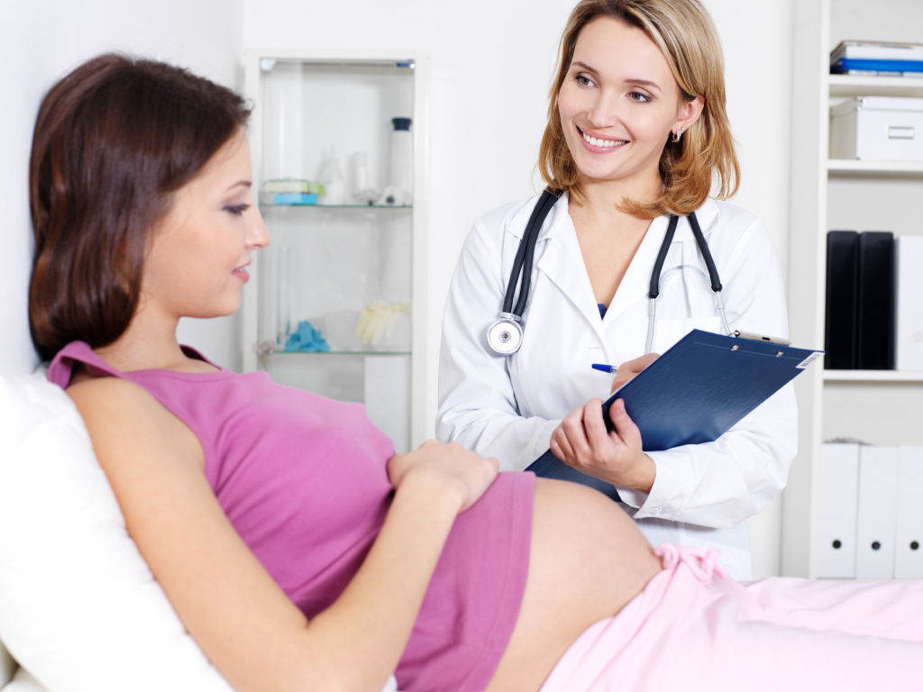 A pregnant woman discussing with a doctor.