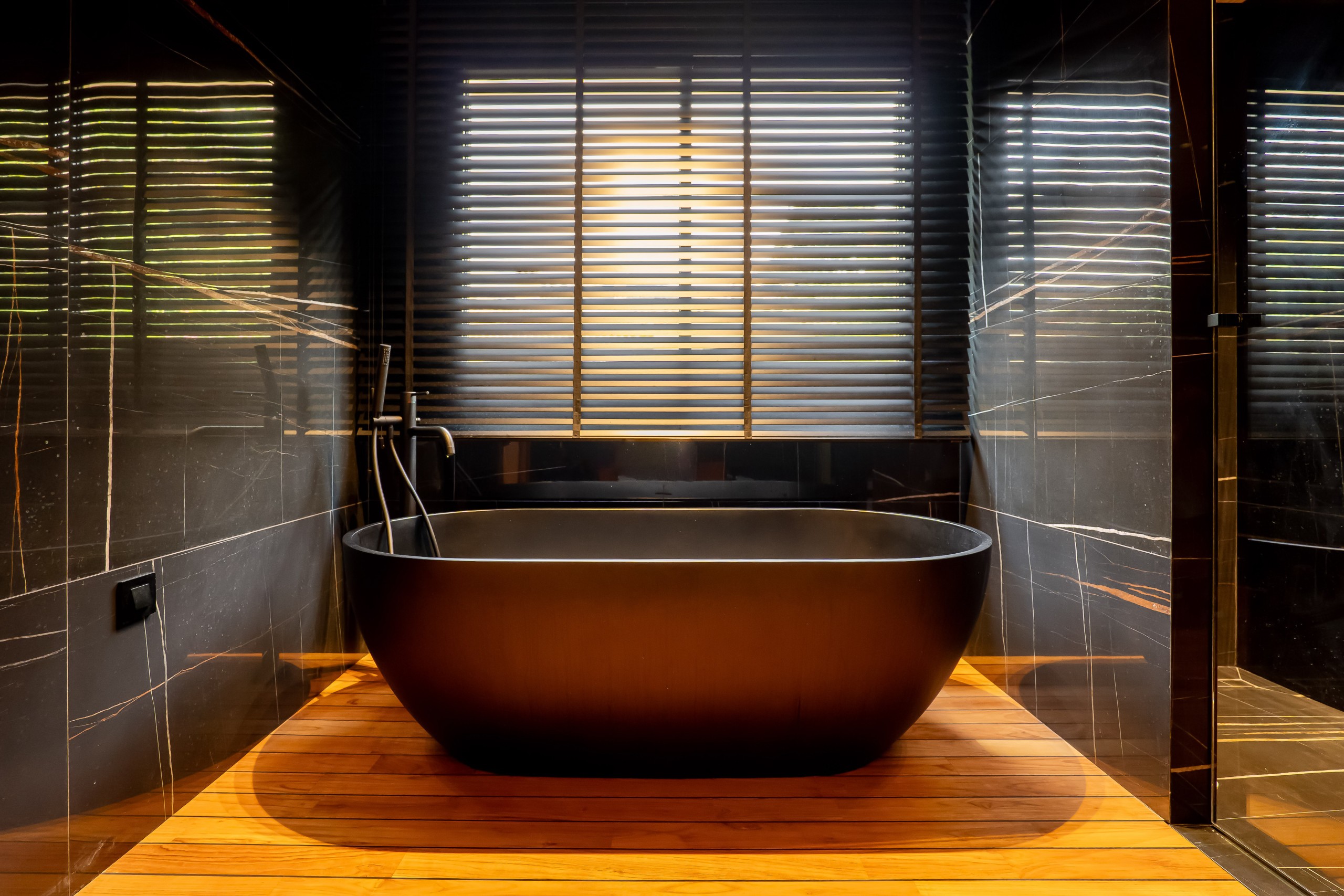 Grey marble bathroom with round mirror and floating sink