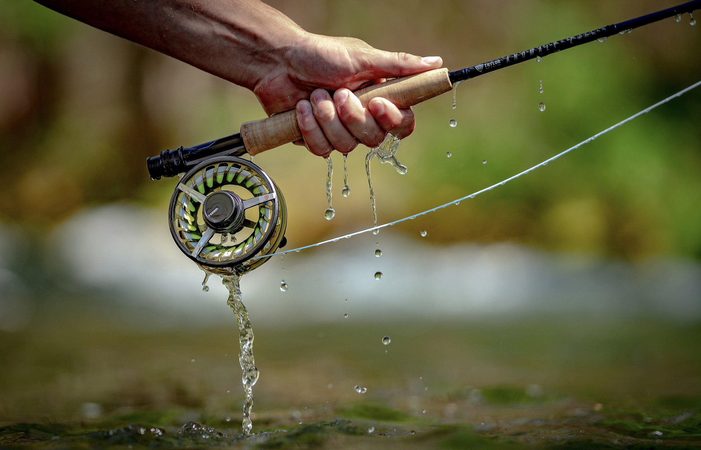 holding fly fishing reel and rod water drip olive color taylor fly fishing