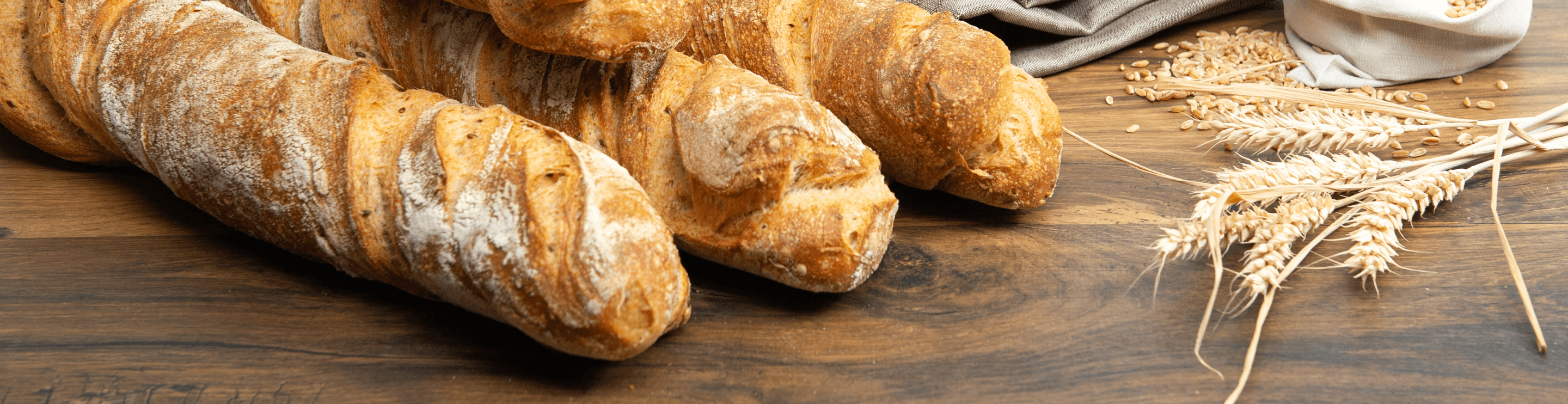 Bild mit drei Baguettes auf einer Holz-Fläche