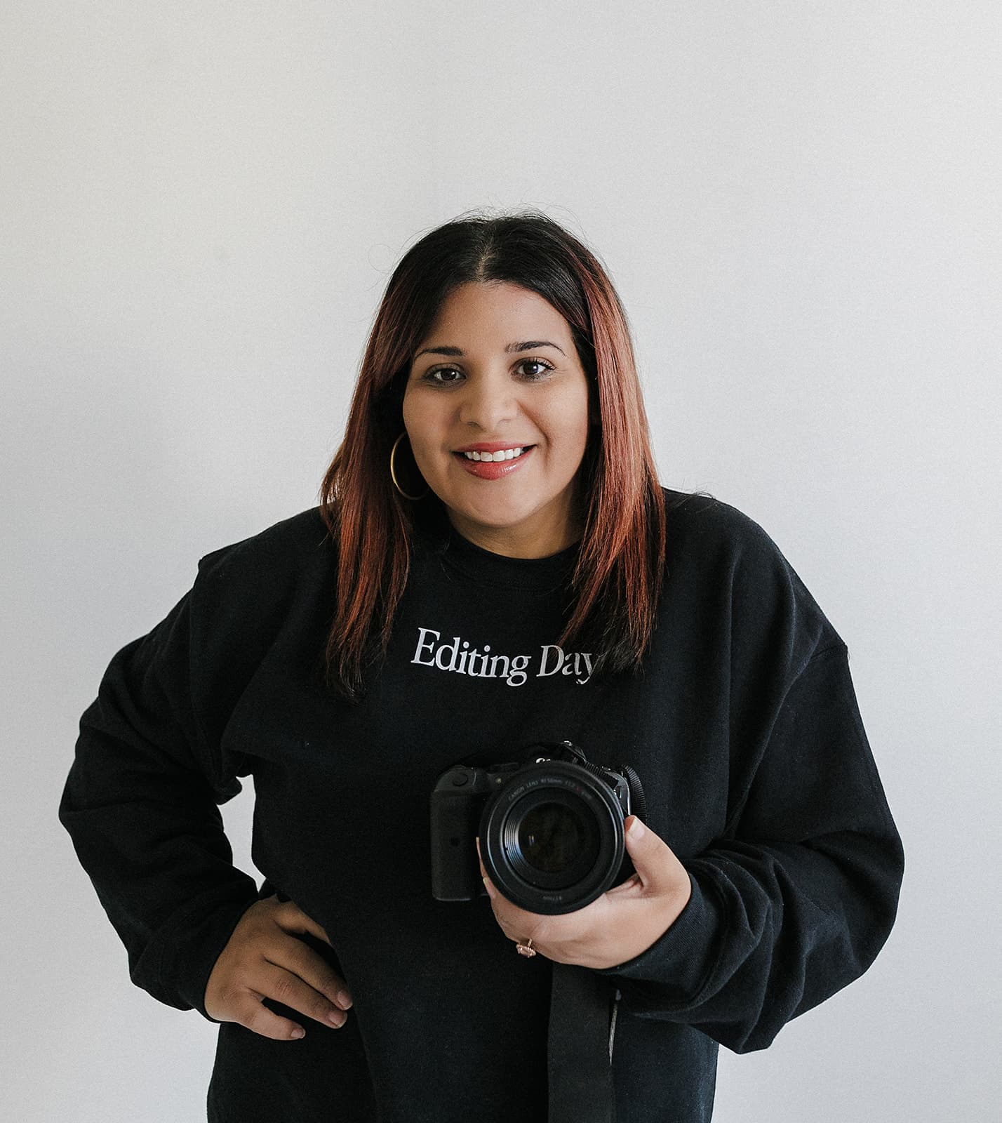 Nicole Marquez holds a camera in hand at Revelator Studio, a natural light photography studio in Shreveport, offering photographers and videographers the perfect space for creative shoots.