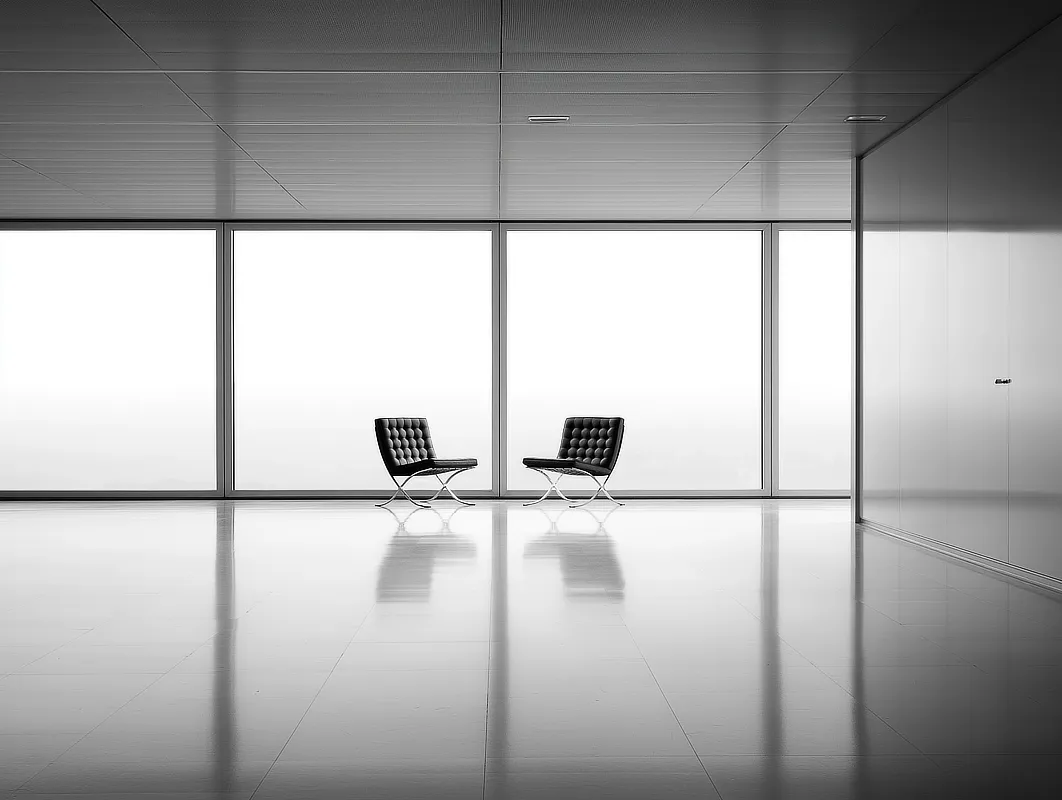 Zwei moderne Stühle in einem Büroraum vor einem großen Fenster