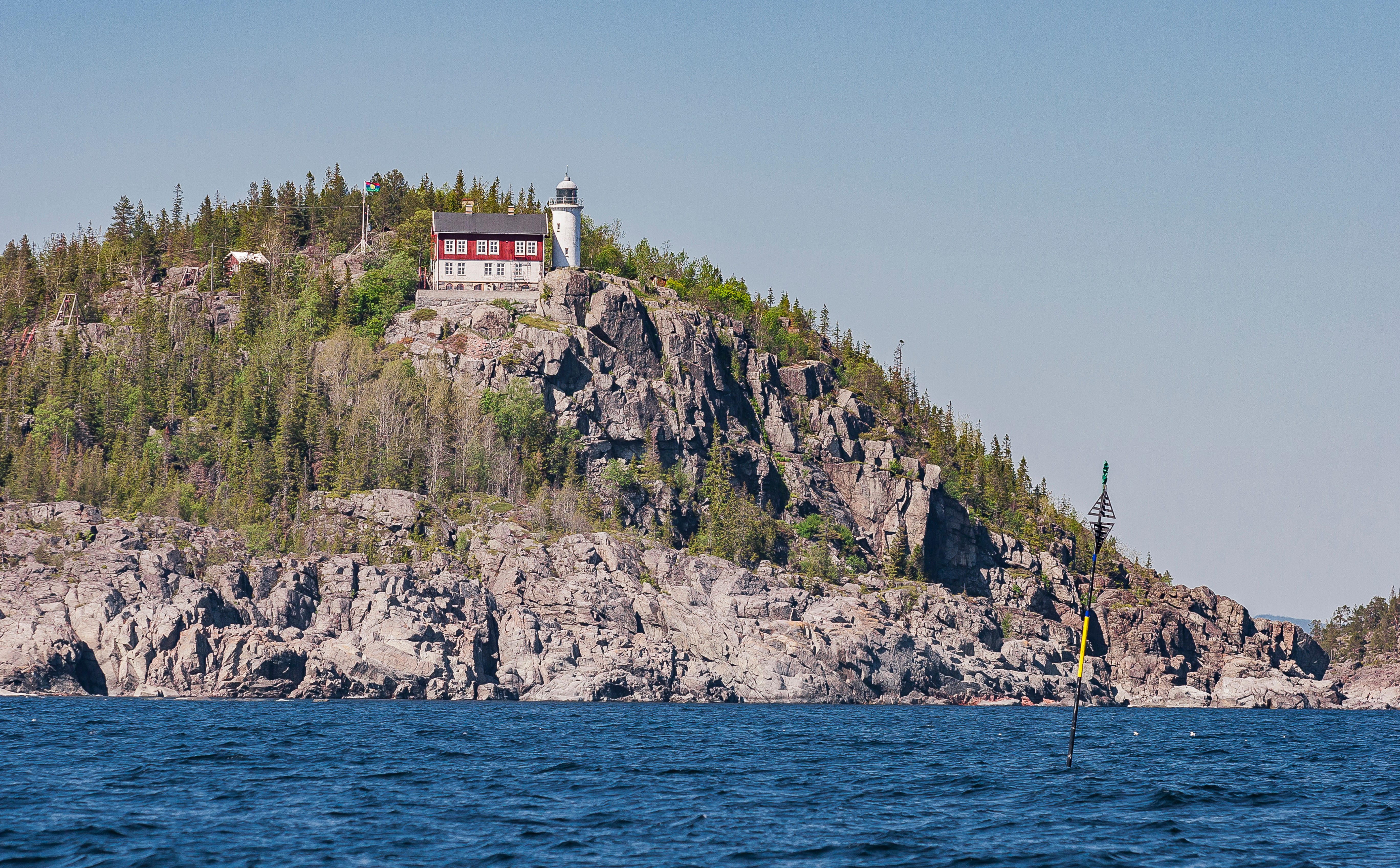 A lighthouse on the top of a cliff on an otherwise deserted Swedish island