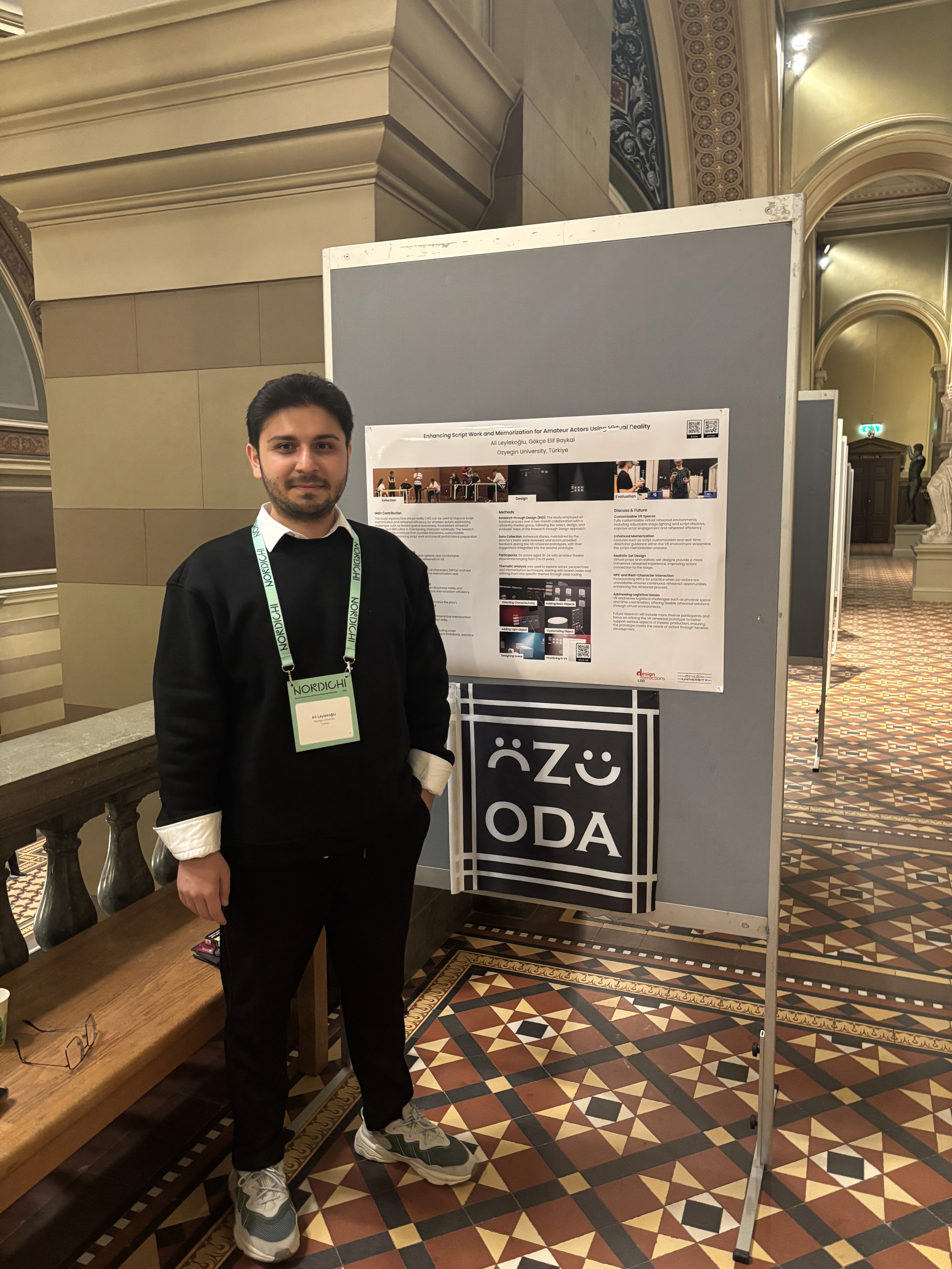 A man presenting a poster about virtual reality and theater at the NordiCHI conference.