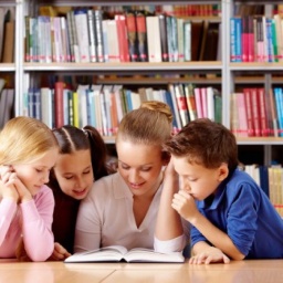 professora com alunos em biblioteca