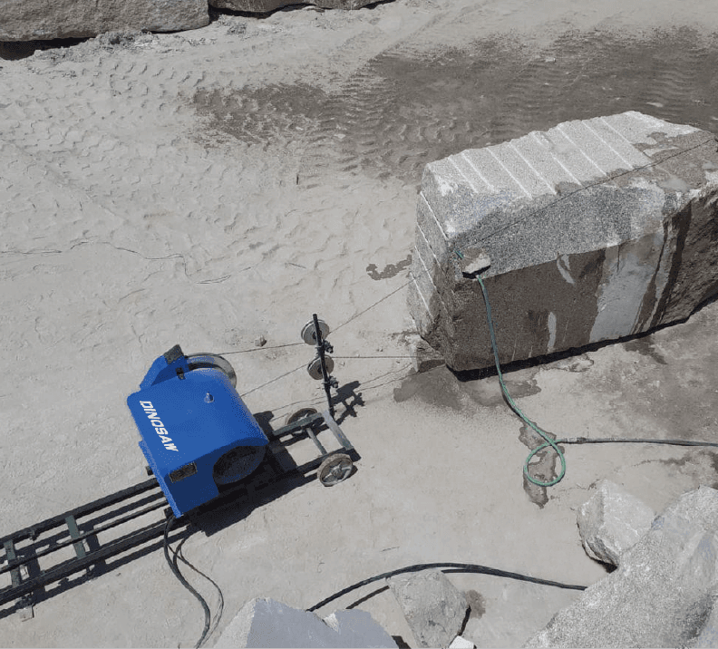 The portable trimming wire saw machine in action, precisely cutting a large stone block in a quarry, showcasing its efficiency and adaptability in various terrains.