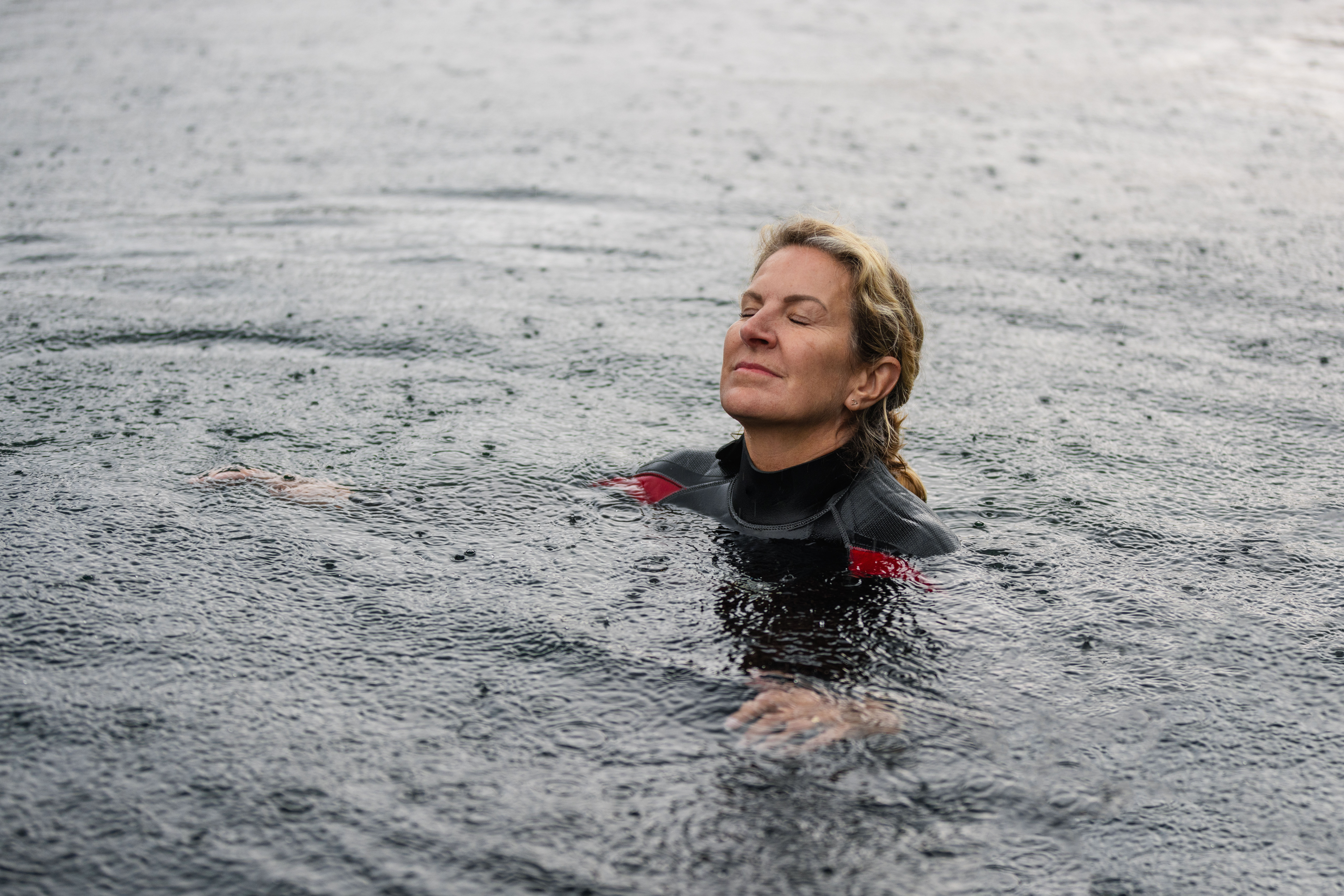 Person enjoying cold water swimming therapy in natural outdoor water