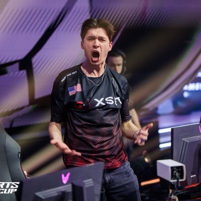 XSET Edgey’s X profile avatar: esports player in XSET jersey shouting with arms outstretched at gaming monitors.