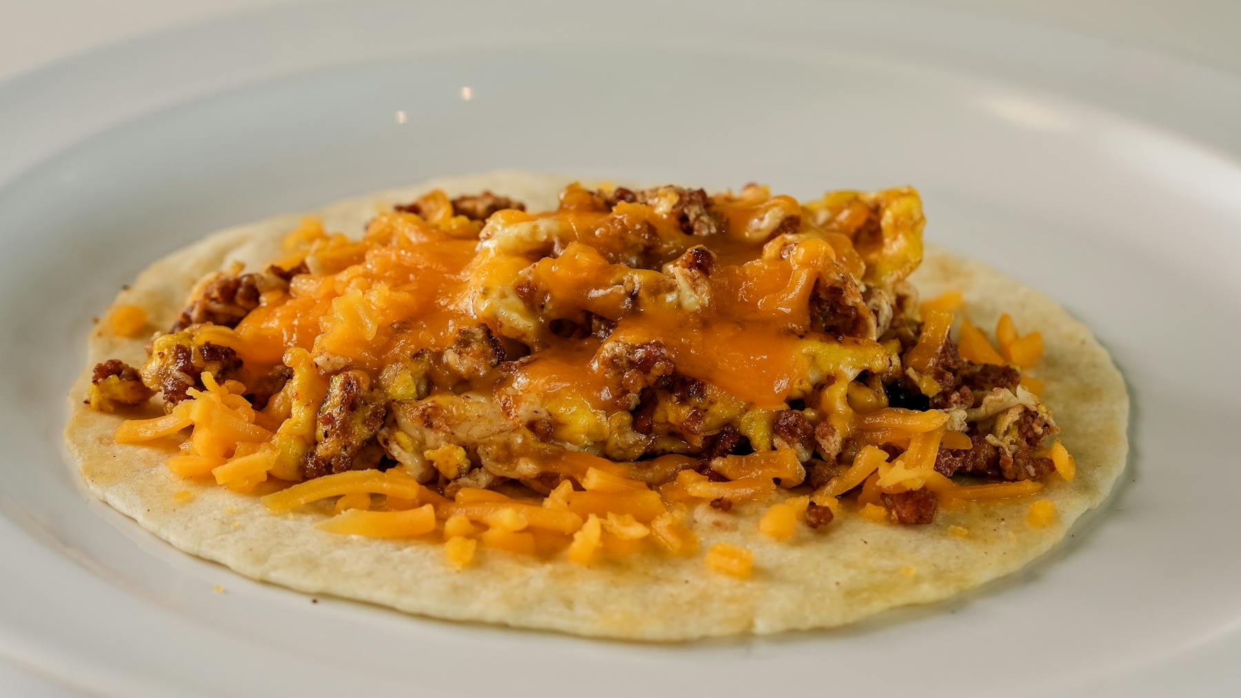 CHORIZO TACO Spicy Mexican sausage with scrambled eggs and melted cheese in a fresh taco shell