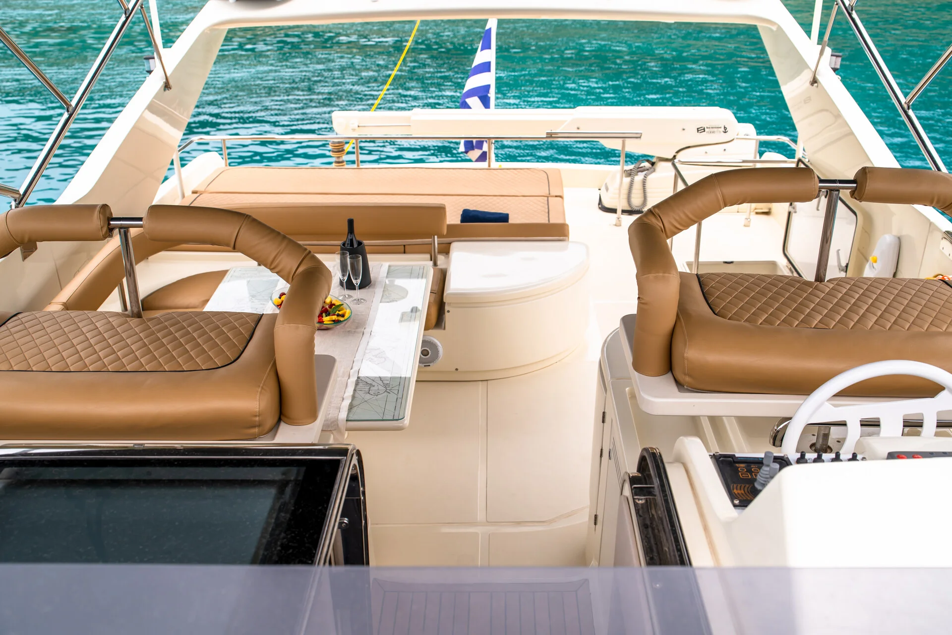 White Rock 36 speedboat with captain at helm cruising calm blue waters near Paros coastline with hills in background.