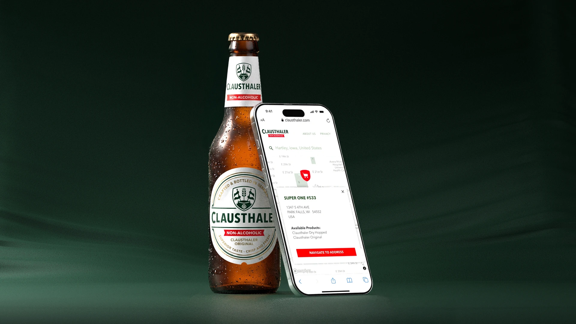 Eine Flasche Clausthaler alkoholfreies Getränk neben einem Handy, auf dem die Website des Unternehmens zu sehen ist.