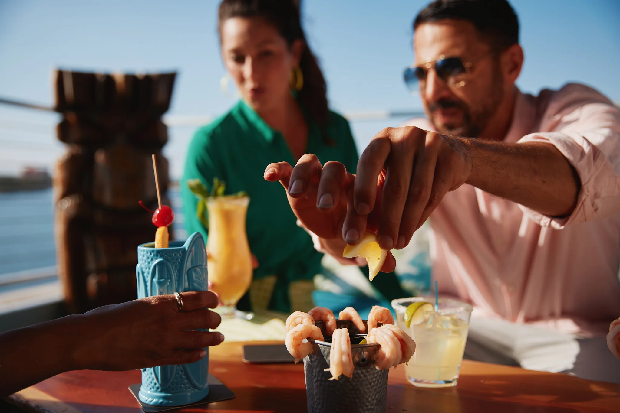 man squeezing lemon over shrimp cocktail — lifestyle photography by Tom Kubik