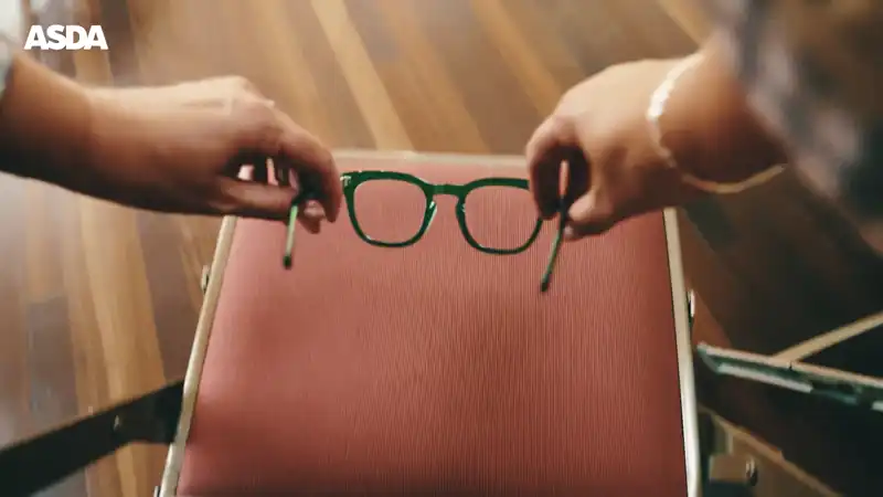 Transition shot picking up a pair of glasses to reveal the full selection available on shelves.