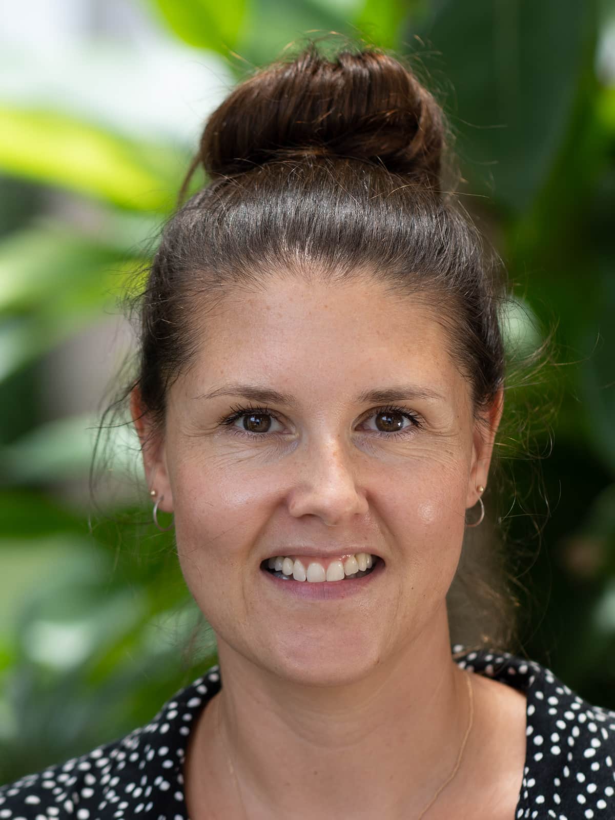 Portretfoto van Tessa Kardoes in een groene, natuurlijke omgeving.