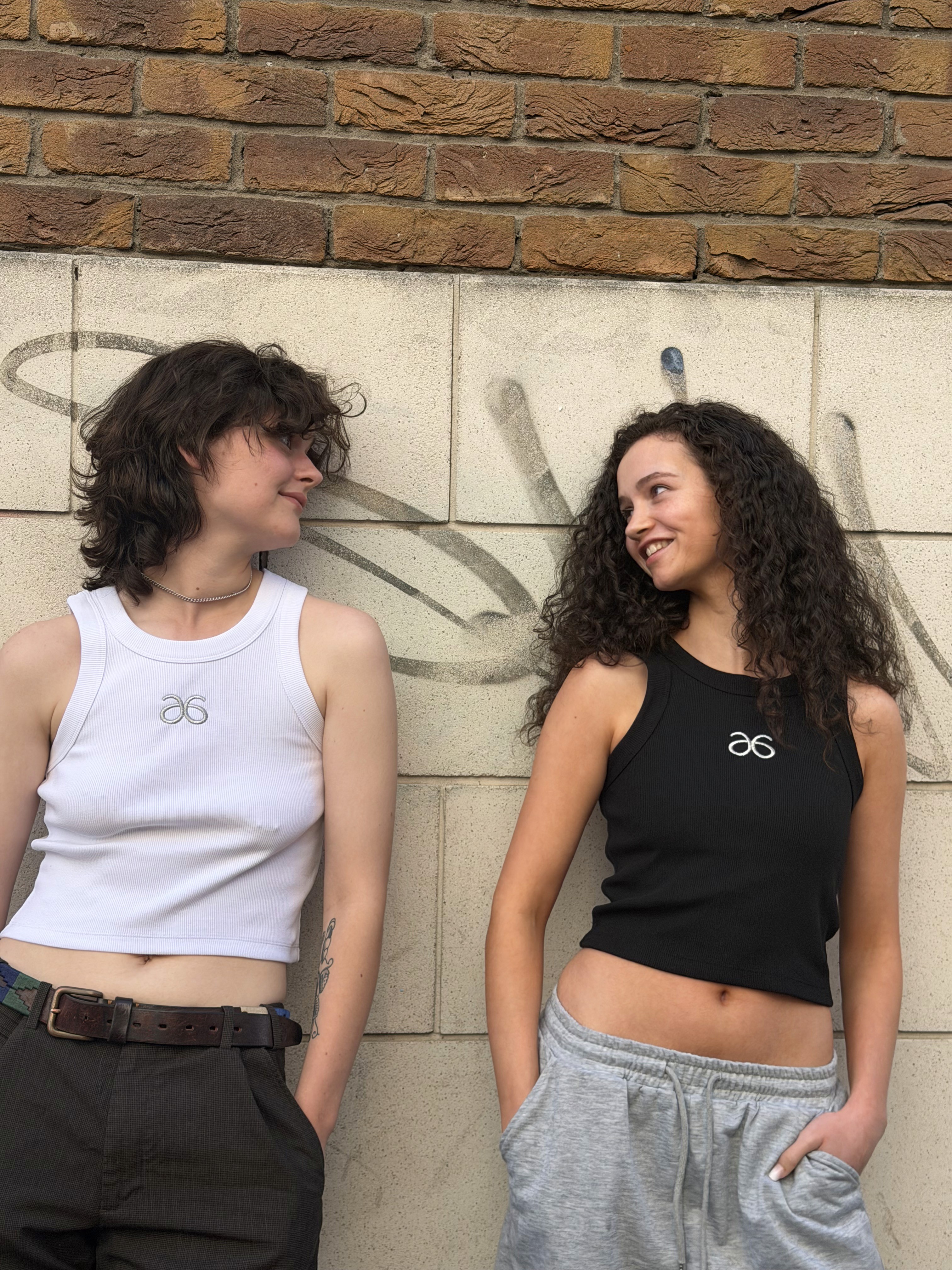 Two 6ISTY6 models wearing rib tanks in an urban setting