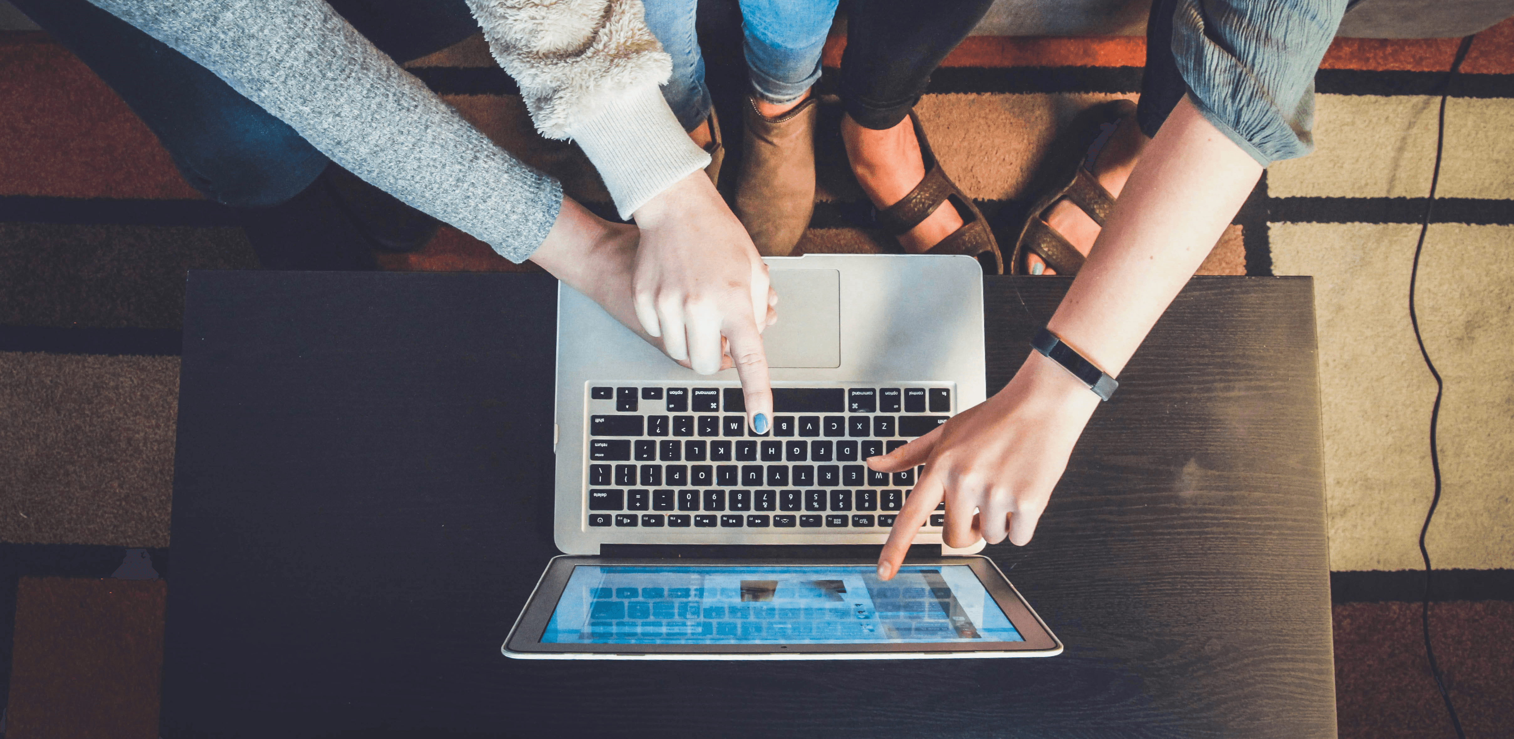 three person pointing the silver laptop computer