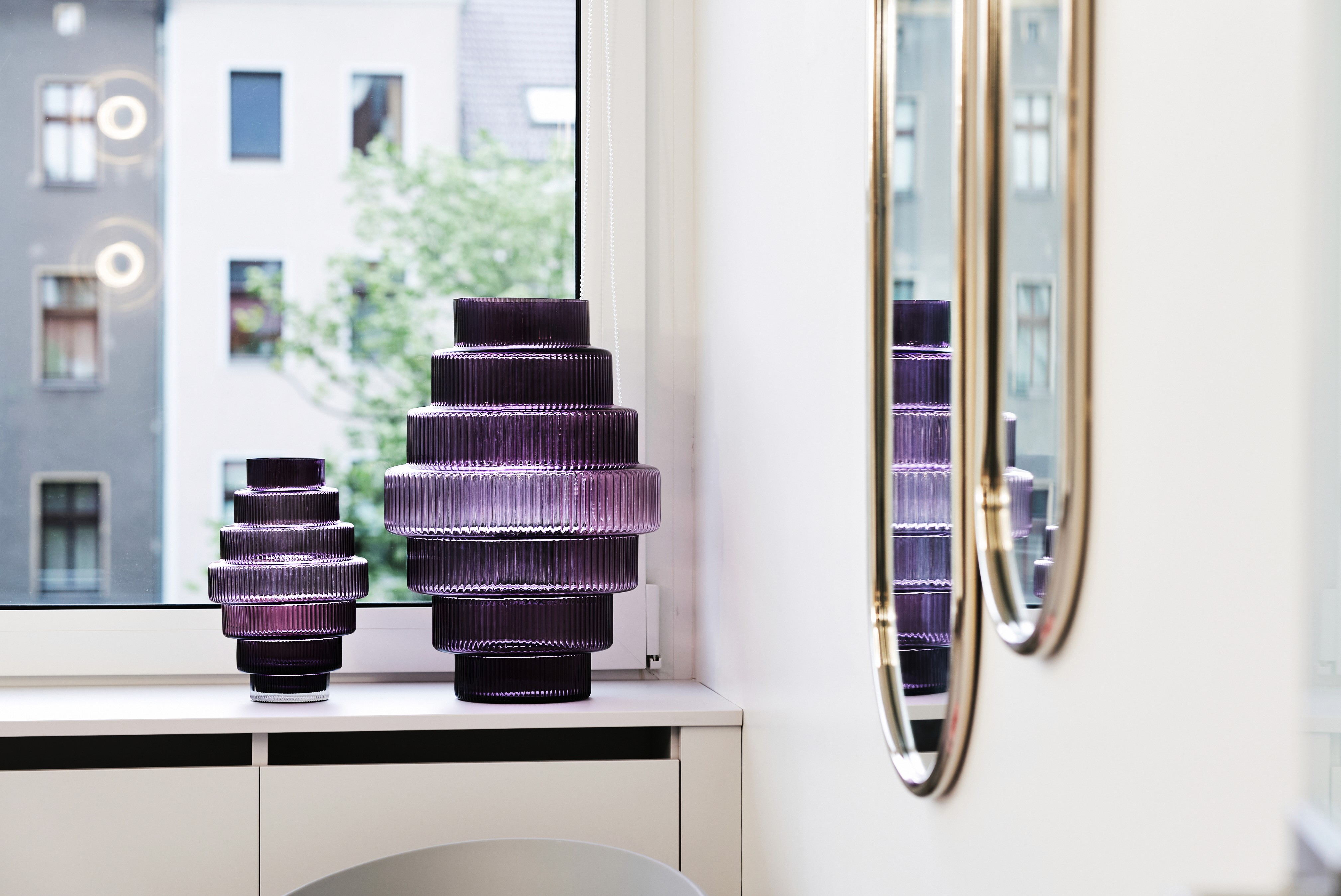 Smiling woman holding documents and using her phone in an office