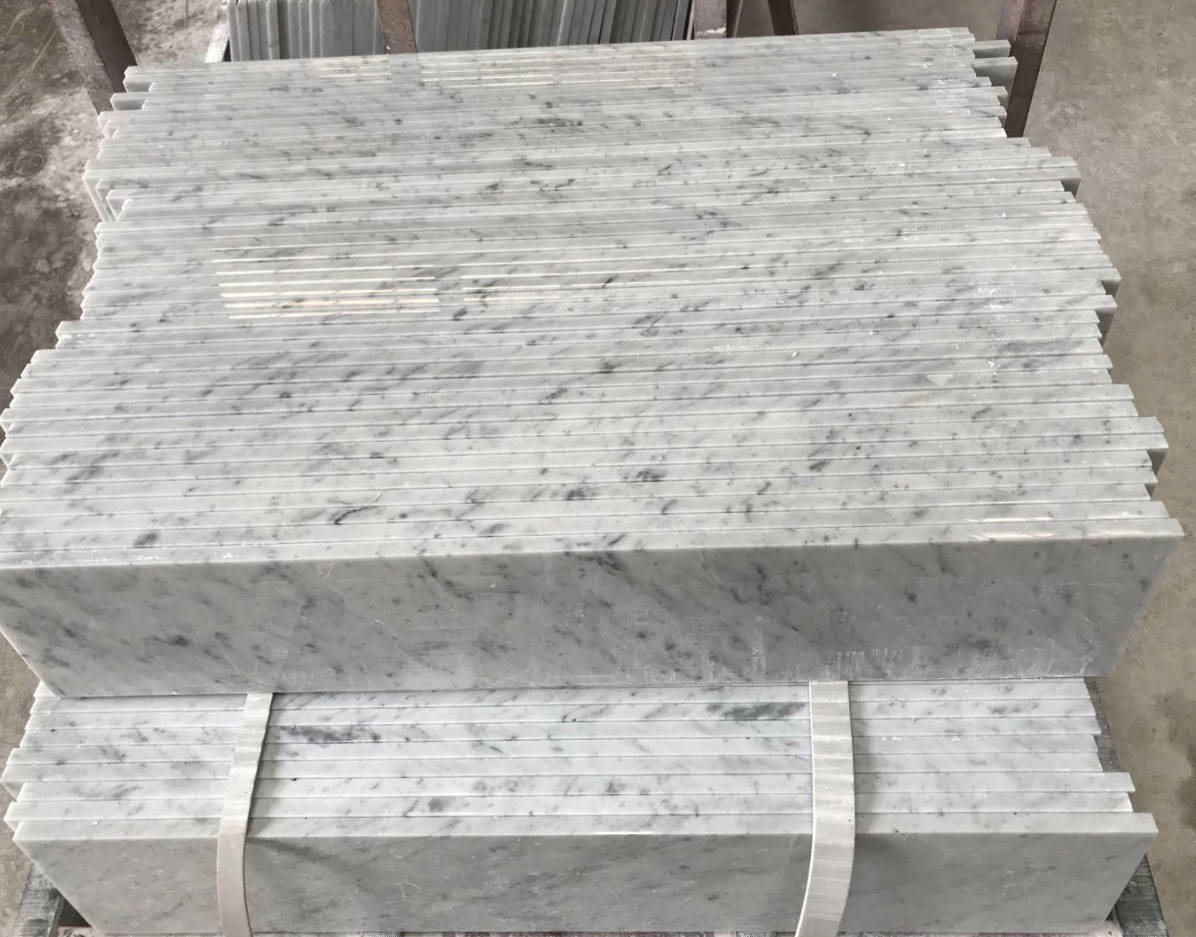 White marble slabs with light gray veining, cut by the Intelligent Laser Bridge Cutting Machine. The slabs are uniformly sized and polished, demonstrating the machine's capability for precise and stable processing.