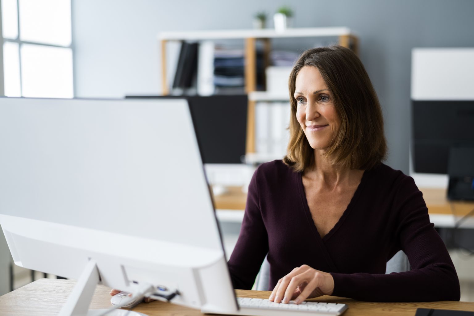 Woman In Office Using Business Computer