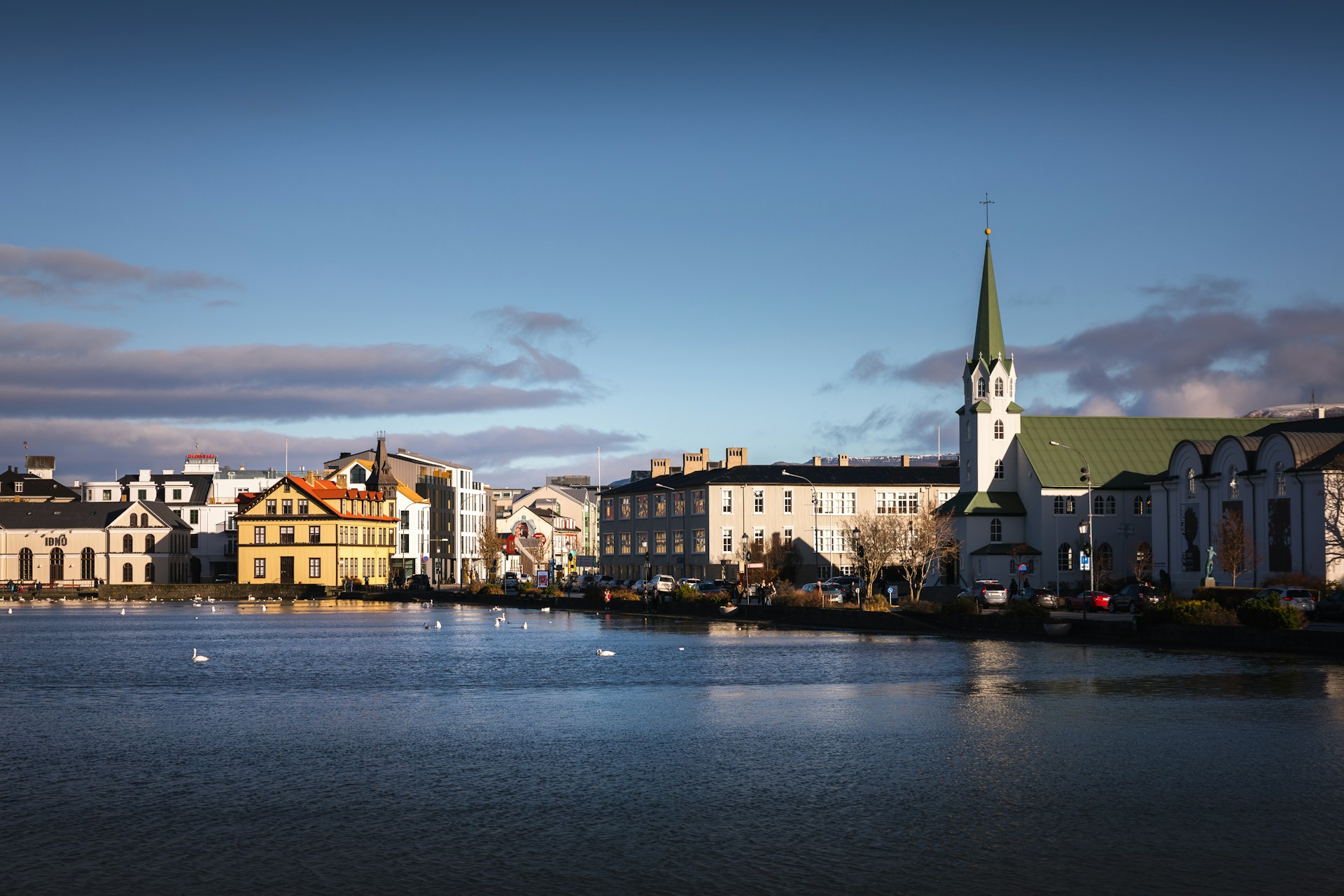 View of Tjörnin Lake and Fríkirkjan church in downtown Reykjavík on a clear day.