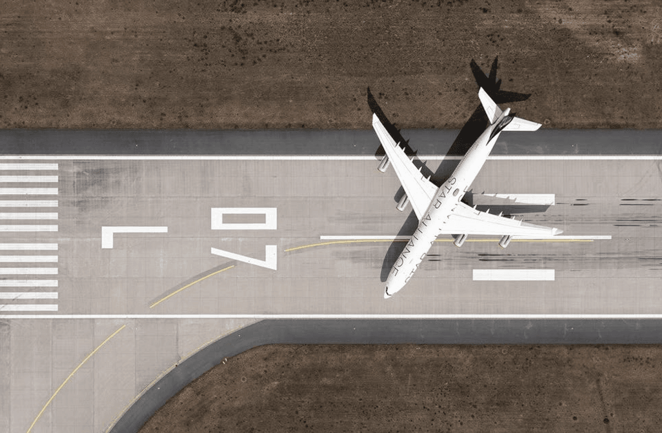 Aerial view of an airplane on the runway, showcasing its sleek design and markings on the ground.