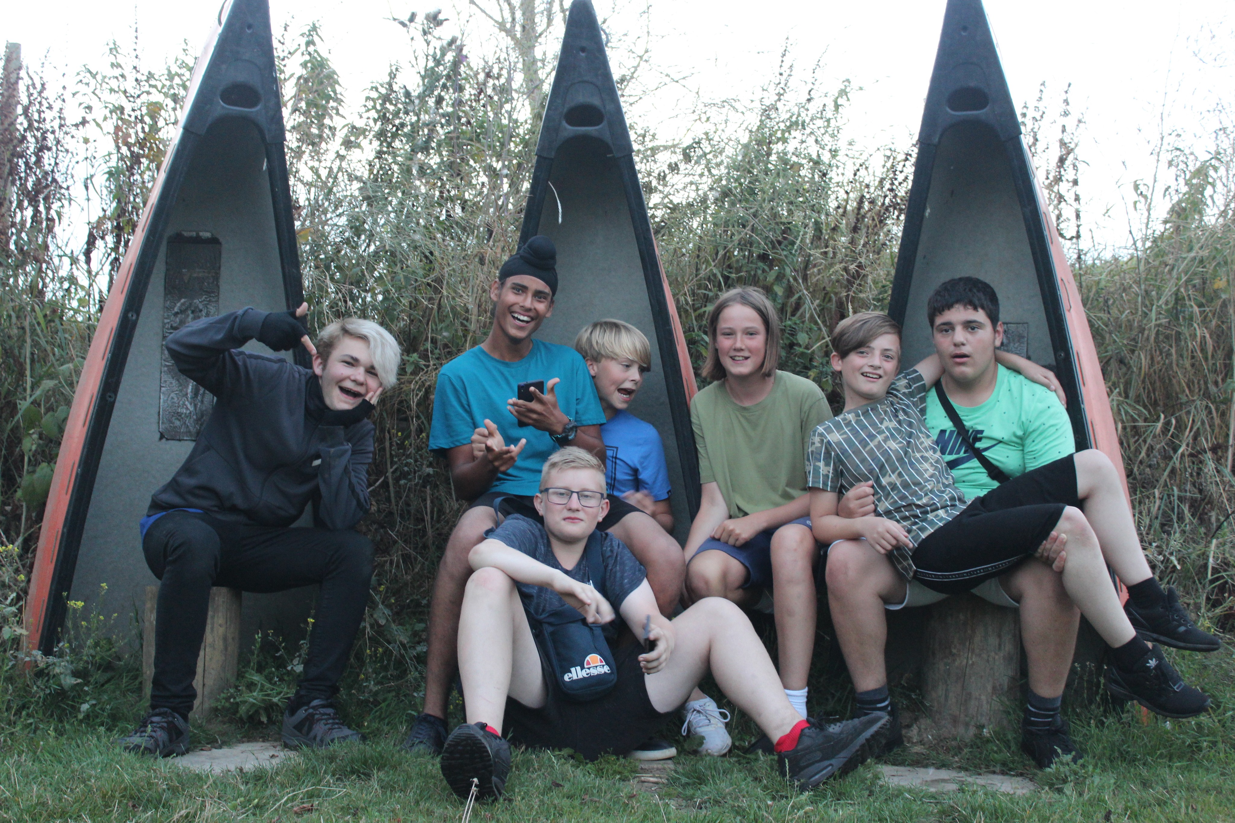 Young people sat in front of boats
