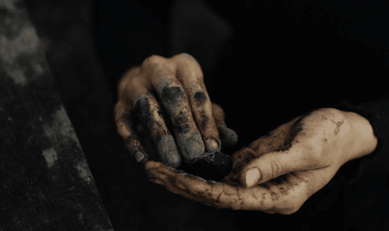 A man playing a drum in front of a group of people