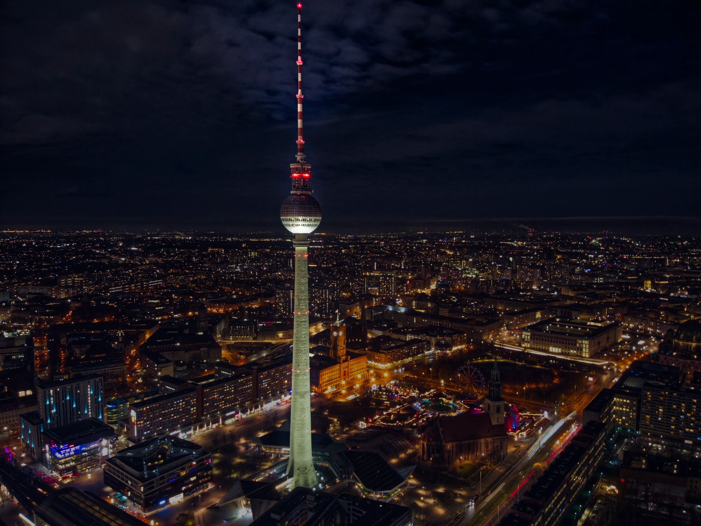Berliner Fernsehturm über der nächtlichen Hauptstadt. Die Drohnenaufnahme zeigt die Skyline Berlins mit dem Fernsehturm als zentrales Wahrzeichen.