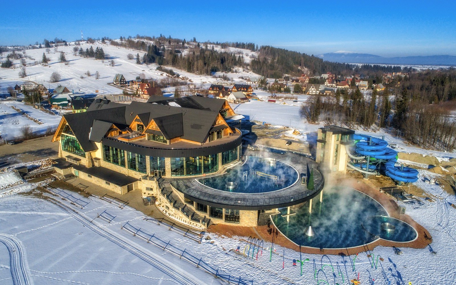 Chocholow Thermal Baths with snow-covered landscape and water slides in Poland.