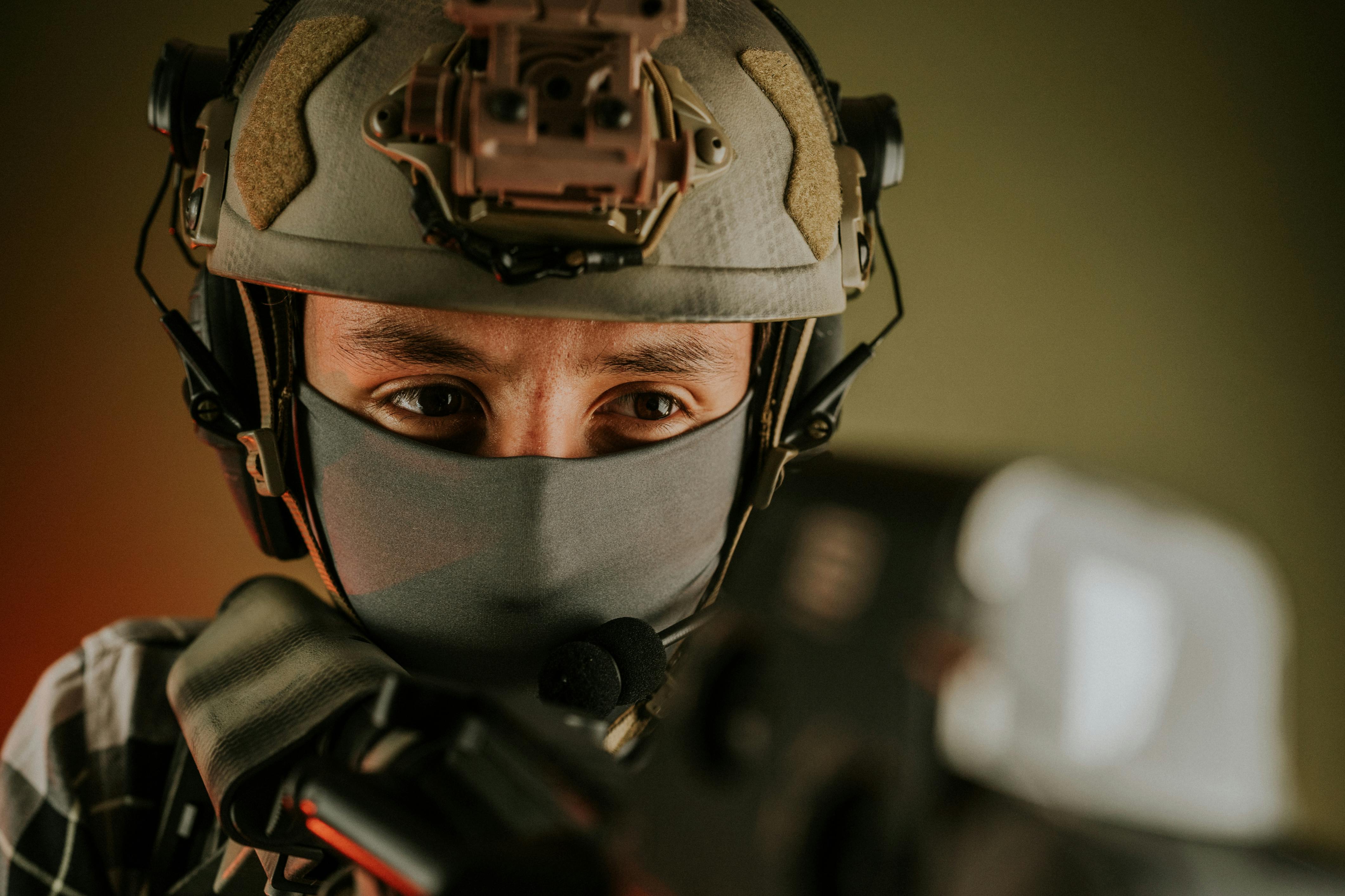 Military drone operator in combat uniform controlling a drone with a remote console, focused on real-time aerial surveillance.