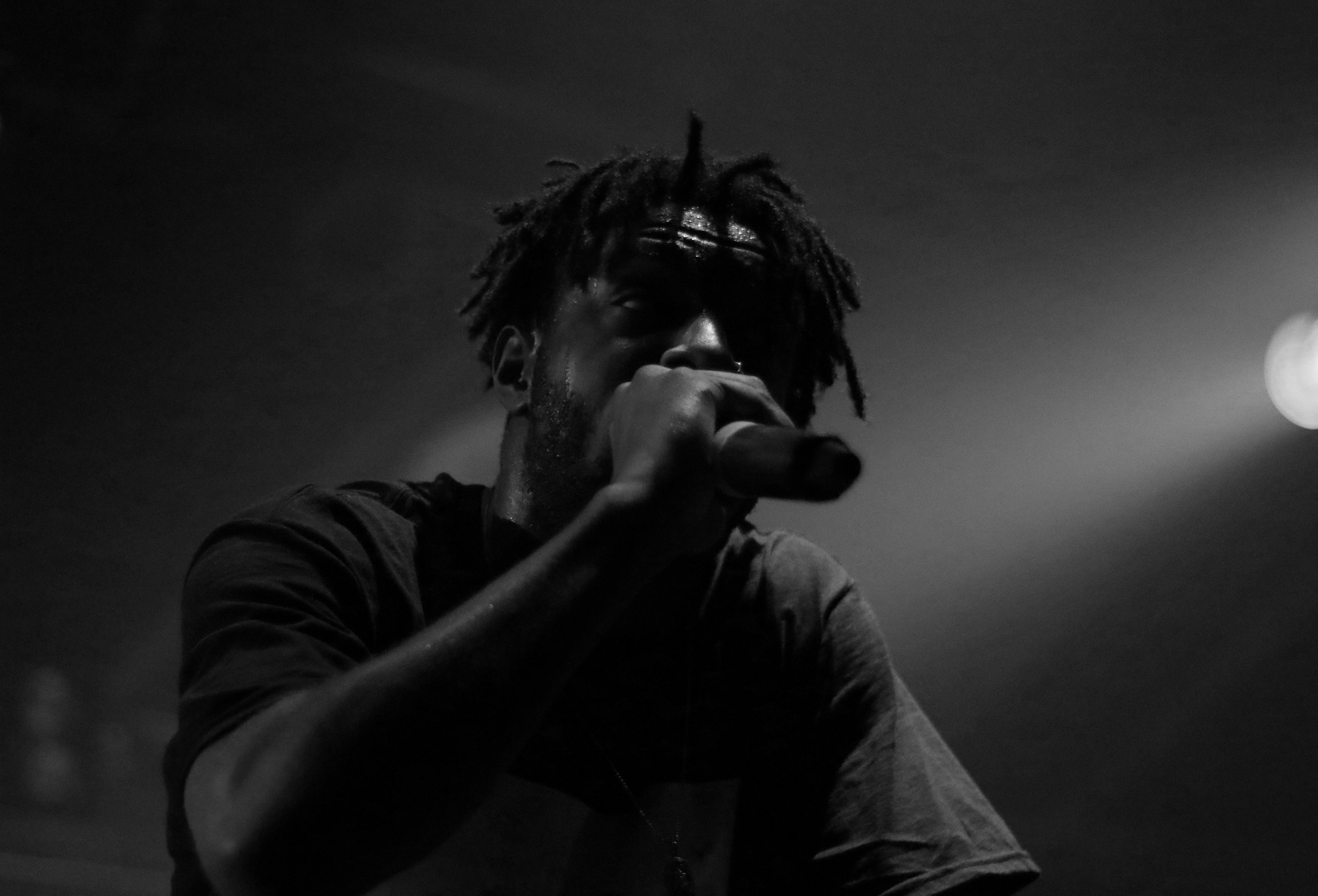 Man rapping into microphone on stage
