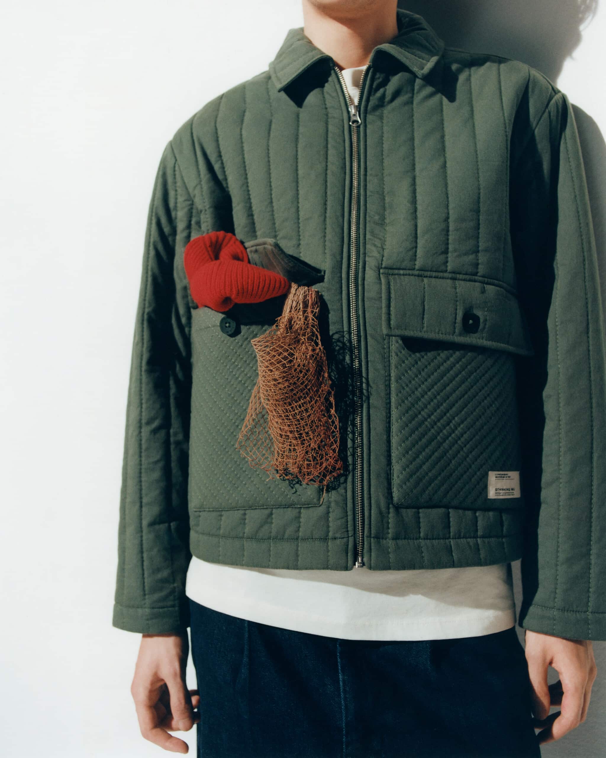 Détail de veste matelassée verticalement de la marque Thinking Mu