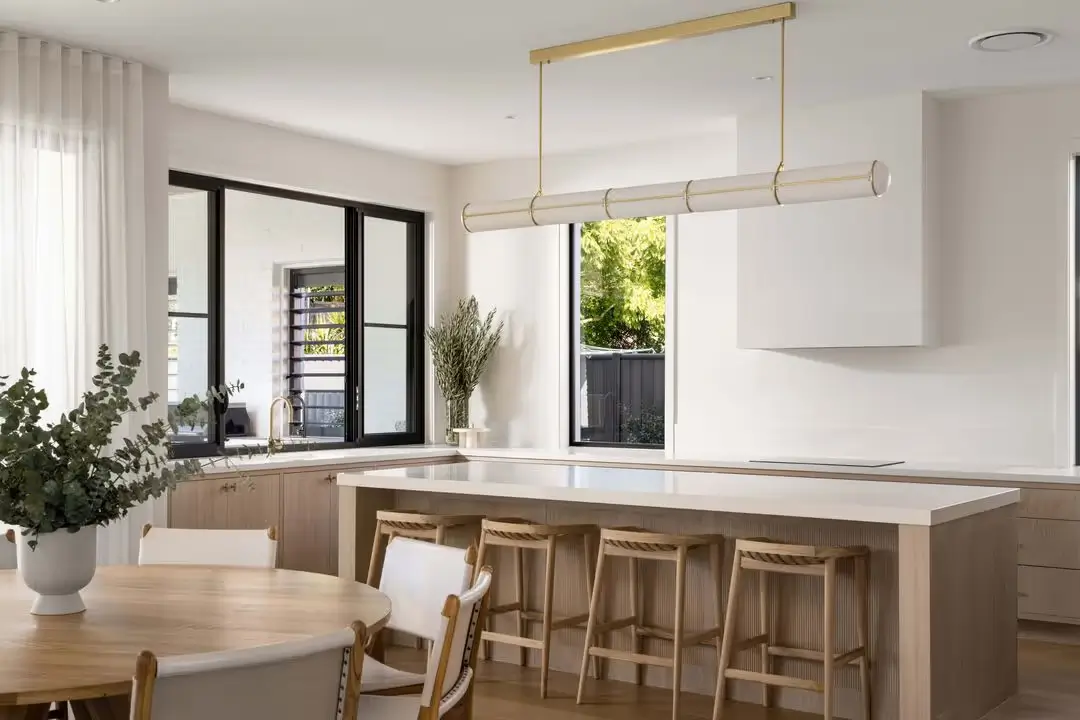A kitchen with a light, neutral colour palette and natural timber elements