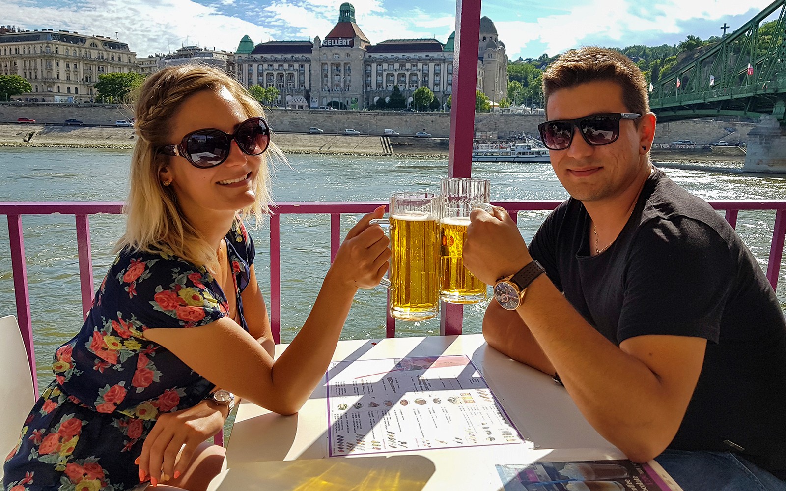 Pár si užívá piva na party lodi v Budapešti s výhledem na panoráma města.