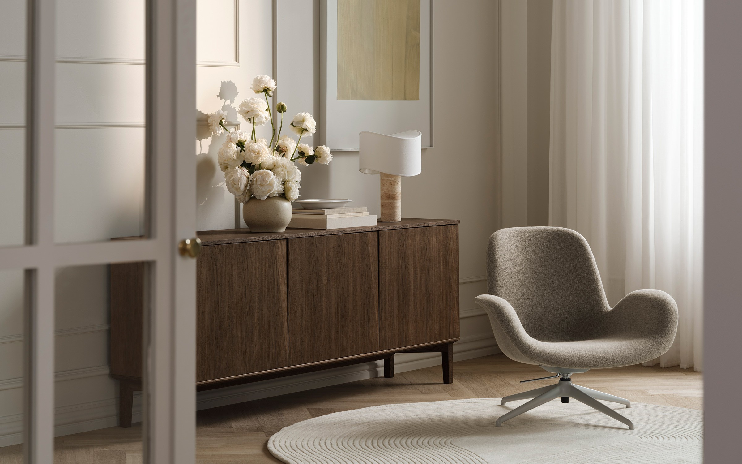 Tajo table lamp in white with stone base placed on wooden sideboard in calm interior designed by Asger Risborg Jakobsen