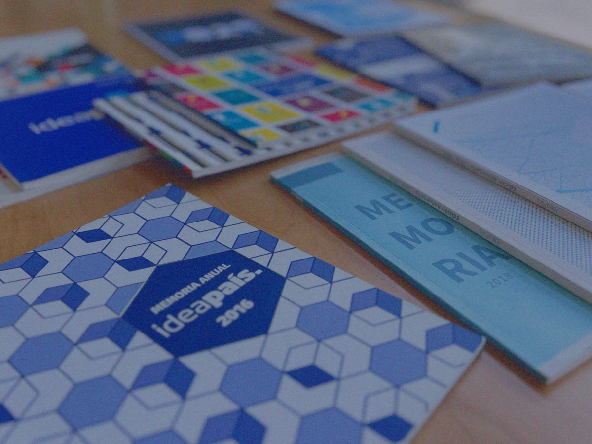 Memorias de distintos años de IdeaPaís sobre una mesa.