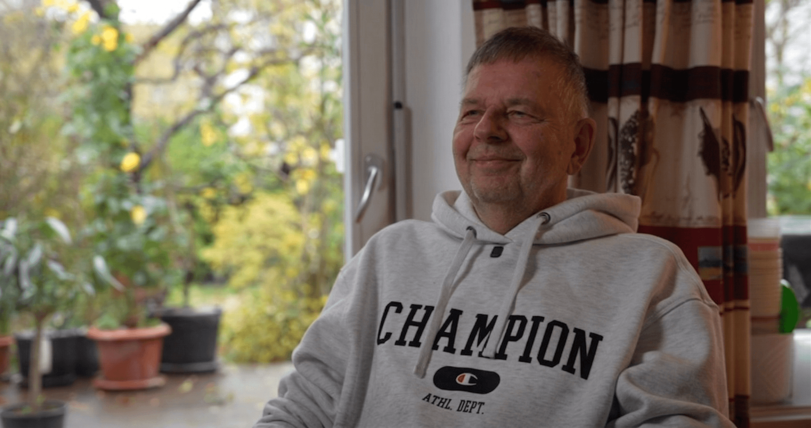 four boys laughing and sitting on grass during daytime