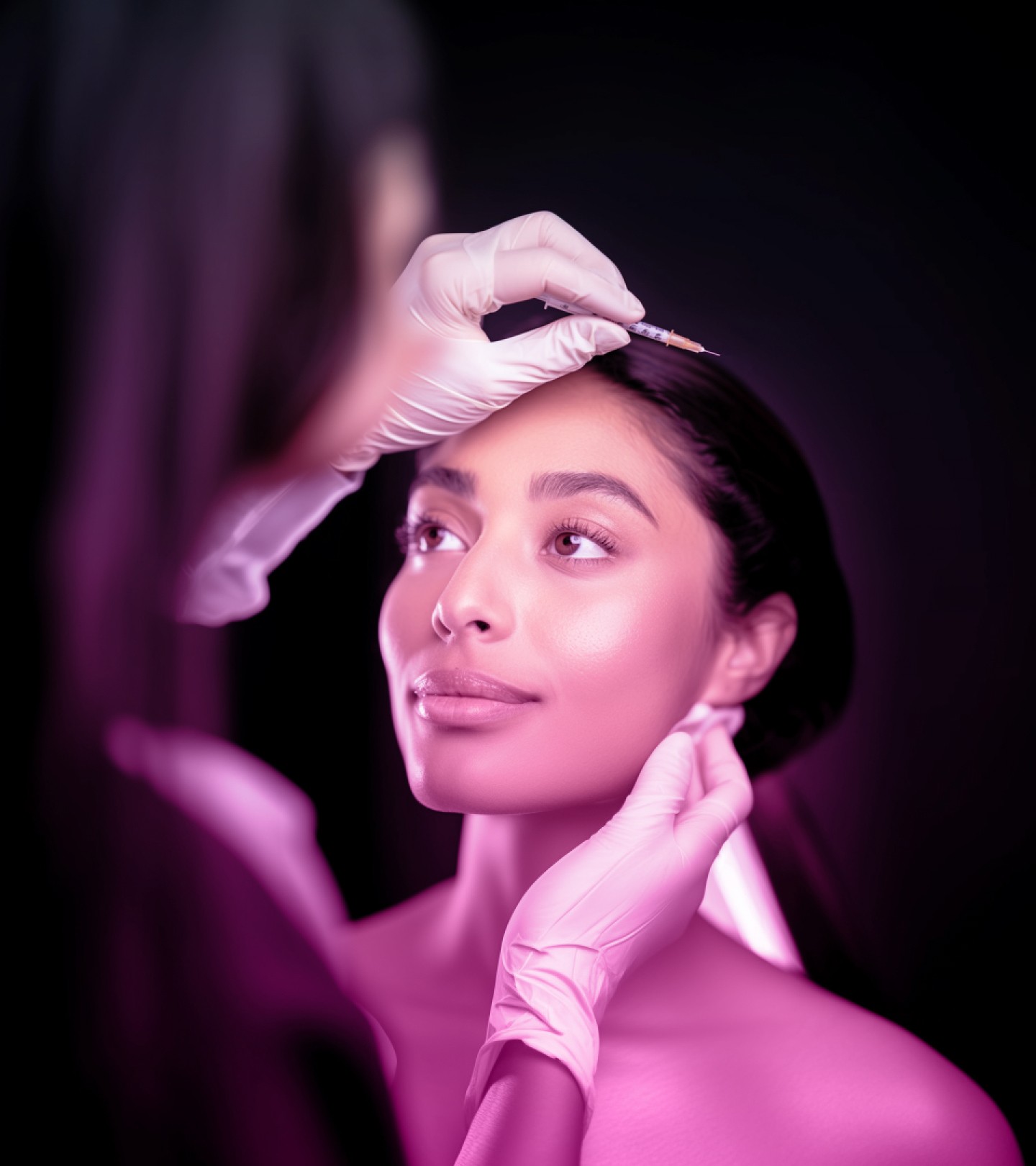 Woman receiving a facial injection, focusing on aesthetics and beauty treatments, with a serene expression under soft lighting.