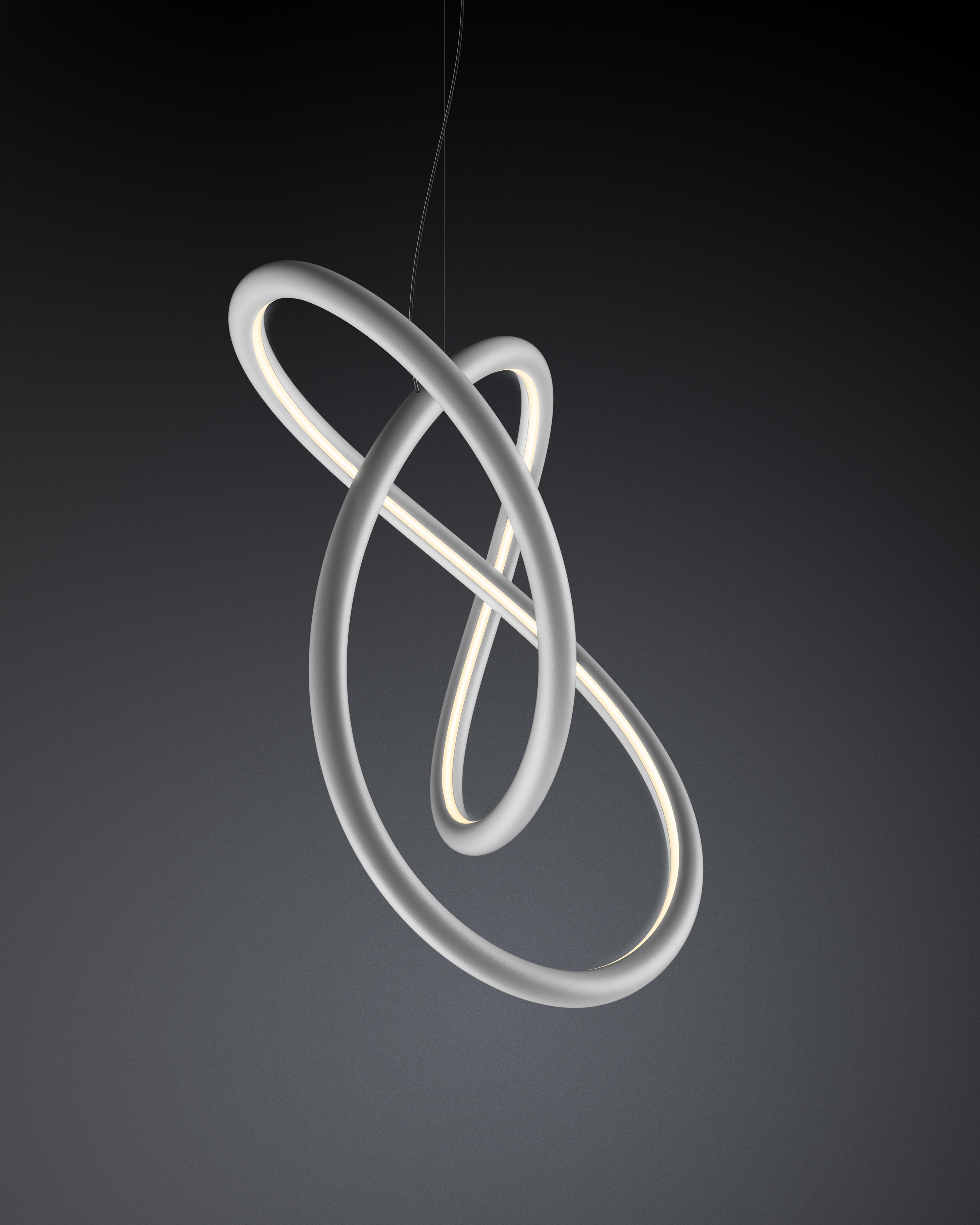 Close-up portrait of a person wearing a gray insulated hooded jacket with the hood up, showing their face framed by the hood against a light background.